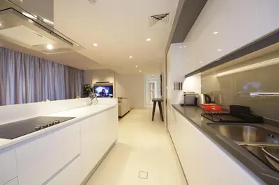 a large kitchen with white counters and a sink at New Arabian Luxury 2 Bedroom In Blue Water in Dubai