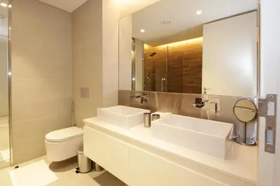 a bathroom with two sinks and a toilet and a mirror at New Arabian Luxury 2 Bedroom In Blue Water in Dubai