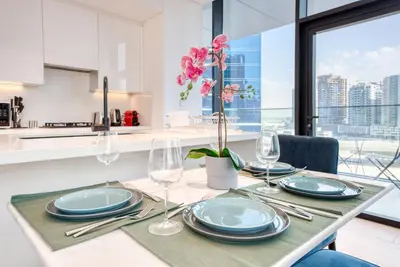 a dining room table with plates and glasses on it at Maison Privee - Luxury, Spacious, Modern Near Burj Khalifa and Dubai Canal in Dubai