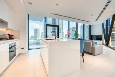 an open kitchen and living room with views of the city at Maison Privee - Luxury, Spacious, Modern Near Burj Khalifa and Dubai Canal in Dubai