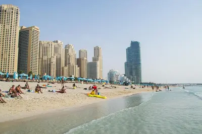 a group of people on a beach with buildings at Silverene Towers Dubai Marina - By Home Of Choice in Dubai