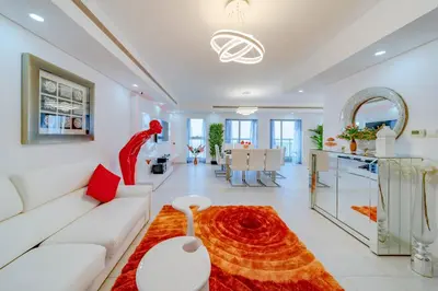 a living room with a white couch and a red rug at Princess Tower highest world Penthouse floor 86! in Dubai