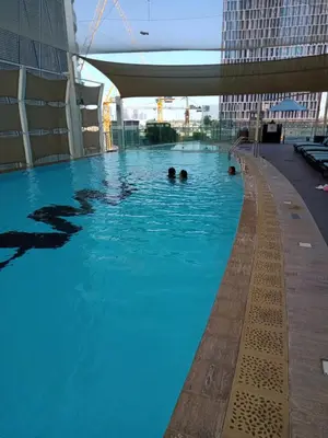 a swimming pool in a building with people in it at HotelApart Dubai Mall st Burj Khalifa View in Dubai