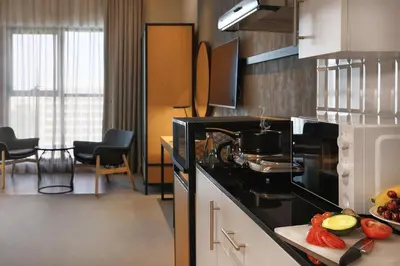 a kitchen with a stove top oven next to a counter at JA The Manor Hotel, Dubai in Dubai
