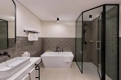a bathroom with a tub and a sink and a shower at JA The Manor Hotel, Dubai in Dubai