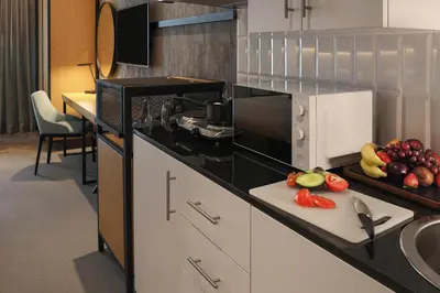 a kitchen with a counter with fruits and vegetables on it at JA The Manor Hotel, Dubai in Dubai