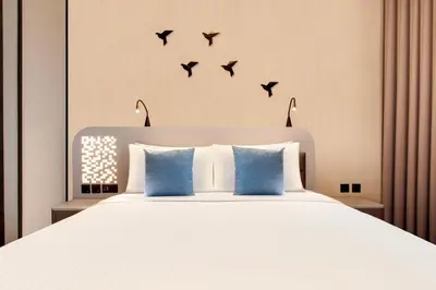 a bedroom with a bed with birds on the wall at Lemon Tree Hotel, Jumeirah Dubai in Dubai