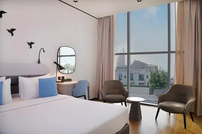 a hotel room with a bed and a large window at Lemon Tree Hotel, Jumeirah Dubai in Dubai