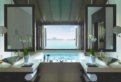 a bathroom with a tub with a view of the water at Anantara The Palm Dubai Resort in Dubai