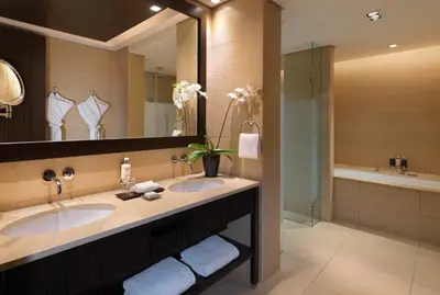 a bathroom with two sinks and a large mirror at Anantara The Palm Dubai Resort in Dubai