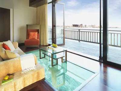 a living room with a couch and a glass table at Anantara The Palm Dubai Resort in Dubai