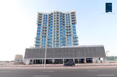 a car parked in front of a large building at Samaya Hotel Apartment Dubai in Dubai