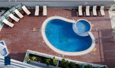 a red brick building with a swimming pool at Samaya Hotel Apartment Dubai in Dubai