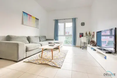 a living room with a couch and a coffee table at Community Vibe Living with Wellness Access Close to Metro, Mediterranean, Discovery Gardens by Deluxe Holiday Homes in Dubai