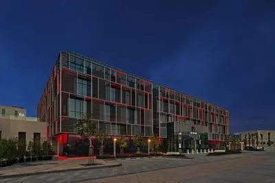 a large red building with a lot of windows at Radisson RED Dubai Silicon Oasis in Dubai