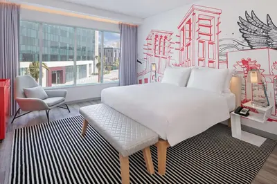 a bedroom with a white bed and a chair and a window at Radisson RED Dubai Silicon Oasis in Dubai