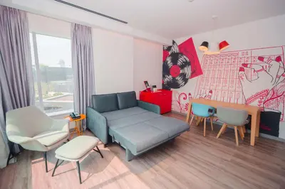a living room with a couch and a table and chairs at Radisson RED Dubai Silicon Oasis in Dubai