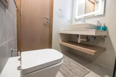 a bathroom with a white toilet and a sink at Cozy 1BR Apart With Pool And Gym 10mins Away By drive to DXB Airport in Dubai