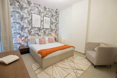 a bedroom with a bed and a chair at Cozy 1BR Apart With Pool And Gym 10mins Away By drive to DXB Airport in Dubai