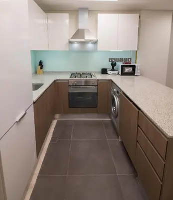 a kitchen with a stove and a dishwasher at Cozy 1BR Apart With Pool And Gym 10mins Away By drive to DXB Airport in Dubai