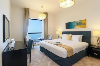 a hotel room with a large bed and a desk and a window at HiGuests - Amazing Sea Views from this 2BR Apt in JBR in Dubai