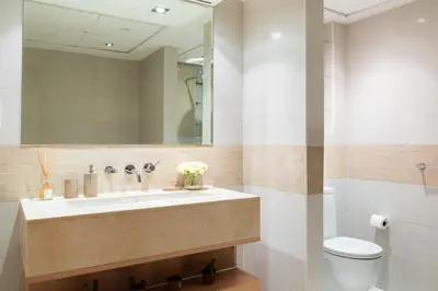 a bathroom with a sink and a toilet and a mirror at Nasma Luxury Stays - Pastel-Colored Apt With Jaw-Dropping Marina Views in Dubai
