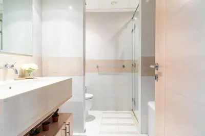 a bathroom with a shower and a sink and a toilet at Nasma Luxury Stays - Pastel-Colored Apt With Jaw-Dropping Marina Views in Dubai
