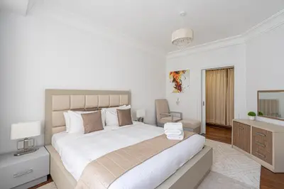 a white bedroom with a large bed and a desk at HiGuests - Luxurious 1BR in Palms with Private Beach Access in Dubai