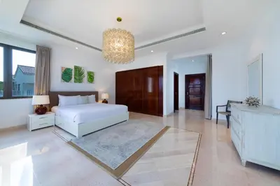a bedroom with a white bed and a chandelier at Maison Privee - 5 Stars Villa with Private Pool or Beach on Palm Jumeirah in Dubai