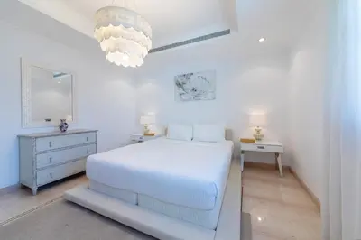 a white bedroom with a white bed and a dresser at Maison Privee - 5 Stars Villa with Private Pool or Beach on Palm Jumeirah in Dubai