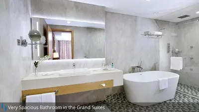 a bathroom with a tub and a large mirror at Grand Cosmopolitan Hotel in Dubai