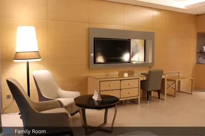 a living room with a tv on a wall at Grand Cosmopolitan Hotel in Dubai
