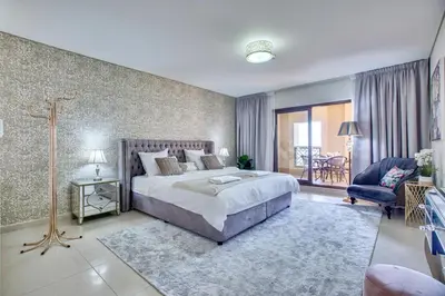 a bedroom with a large bed and a living room at Luxury Apartments at Balqis Residence in Dubai
