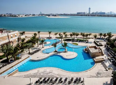 an aerial view of a resort swimming pool with the beach at Luxury Apartments at Balqis Residence in Dubai