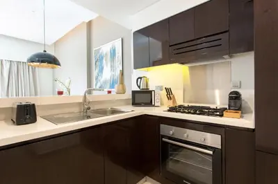 a kitchen with a sink and a stove top oven at Staycae Holiday Homes - Majestine in Dubai