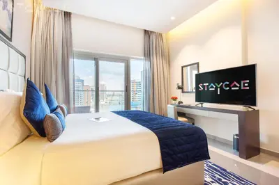 a hotel room with a large bed and a television at Staycae Holiday Homes - Majestine in Dubai