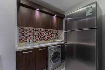 a kitchen with a stainless steel refrigerator and a washing machine at Holiday Apartment in Palm Jumeirah with Beach Access in Dubai