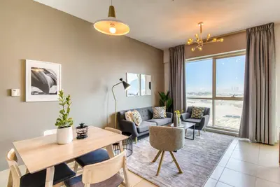 a living room with a table and chairs and a couch at GuestReady Holiday Homes - Sunny Delights in Dubai