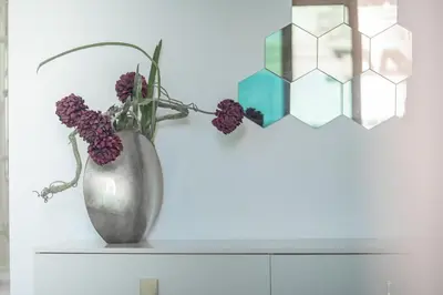 a vase with flowers on a shelf with a lamp at HiGuests - Spacious 1BR in Dubai Marina With Amazing Views in Dubai