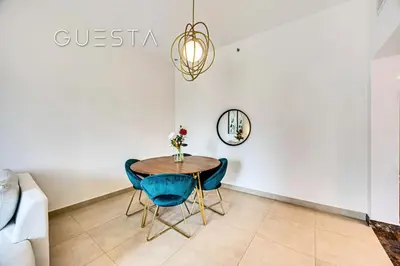 a dining room with a table and blue chairs at Sparkle Tower, Dubai Marina in Dubai