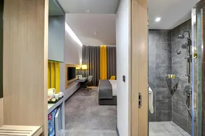 a hotel room with a bathroom and a bedroom at URBAN Al Khoory Hotel in Dubai