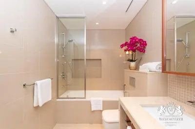 a bathroom with a shower and a toilet and a sink at Westminster Boulevard Point in Dubai