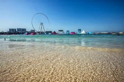 a sandy beach with a ferris wheel in the background at 1 Bedroom with Stunning Ain Dubai and Full Sea View in Dubai
