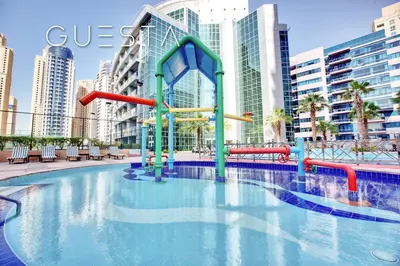 a pool with a water slide in a city at The Waves by DAMAC, Dubai Marina in Dubai