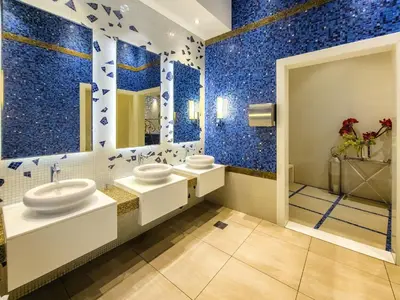 a bathroom with two sinks and blue tiles at Ultra modern 1BD in Damac Heights Marina in Dubai