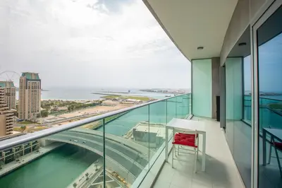 a red chair sits on the balcony of a building at Ultra modern 1BD in Damac Heights Marina in Dubai