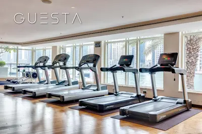 a row of treadmills in a gym with windows at Al Majara, Tower 1, Dubai Marina in Dubai