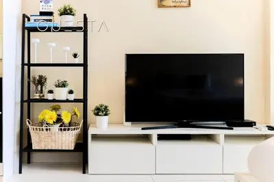 a living room with a television on a white entertainment center at Club Vista Mare, free Riva beach club access in Dubai
