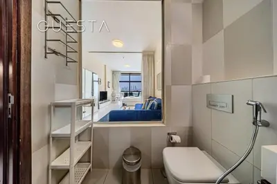 a bathroom with a toilet and a mirror at Club Vista Mare, free Riva beach club access in Dubai