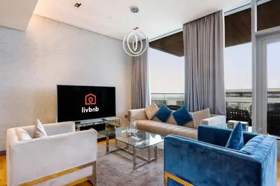 a living room with a couch and a tv at Bluewaters Island - High-Floor 1 Bedroom Suite by Livbnb in Dubai